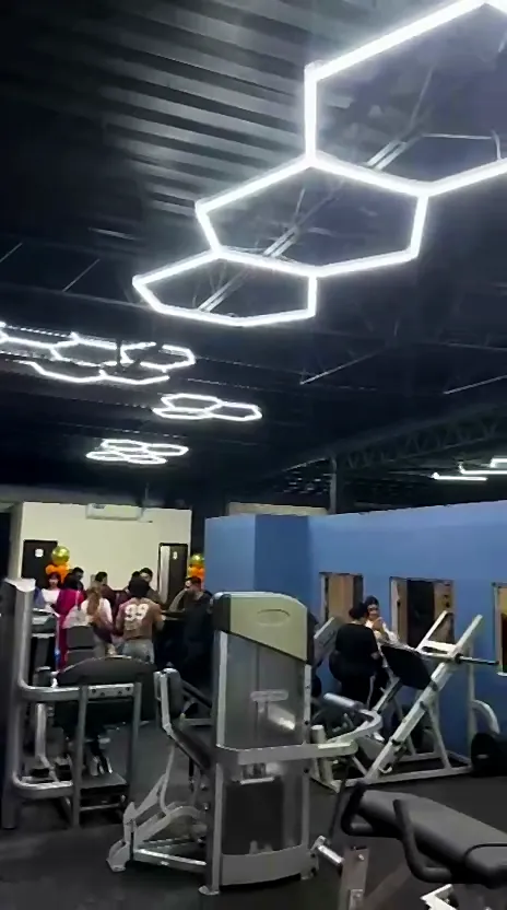 Invitados recorriendo las máquinas bajo las lámparas hexagonales